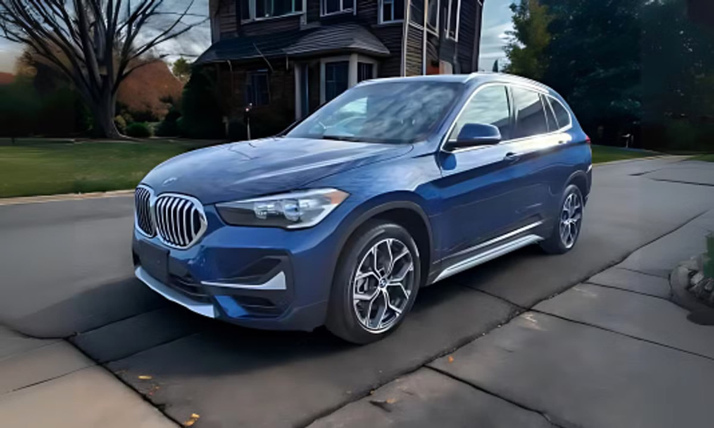 Rentalp's 2021 BMW X1 in metallic blue, parked in a suburban driveway